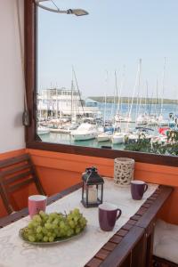 a table with a plate of grapes on it with a window at Harbour-Apartment with sea view and parking spot in Pula