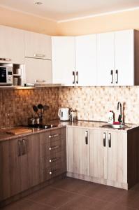 a kitchen with wooden cabinets and white appliances at Gudauri Palace Apartments in Gudauri
