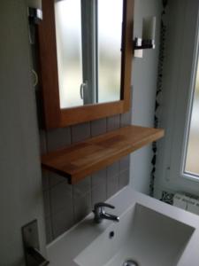 La salle de bains est pourvue d'un lavabo et d'un miroir. dans l'établissement Maison de vacances cosy, à Avranches