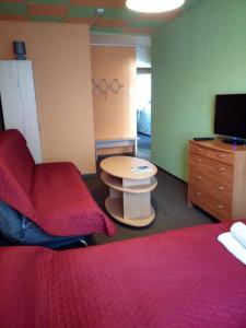 Cette chambre comprend 2 lits, une table et une télévision. dans l'établissement Nakvynė Anykščių centre, à Anykščiai