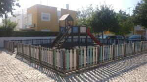 um parque infantil com um escorrega atrás de uma cerca em Manta Rota Beach Haven em Manta Rota
