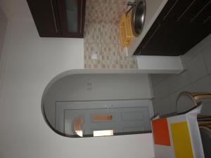Tolna的住宿－Vass-Lak Apartman ,Tolna，厨房配有镜子和白色橱柜