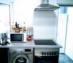 a small kitchen with a stove and a microwave at New Trendy apartment in Valencia