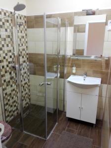 Kerékvár apartman Gyula في غيولا: حمام مع دش ومغسلة