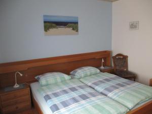 - une chambre dotée d'un lit avec une photo sur le mur dans l'établissement FeWo Trientje, à Uplengen