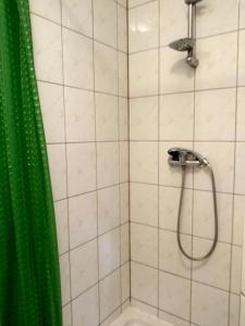 a bathroom with a shower with a green shower curtain at Schronisko Młodzieżowe Małgosia in Łazy