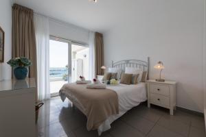プエルト・デ・モガンにあるMogan Beachfront | CarmitAtHomeの海の景色を望むベッドルーム1室(大型ベッド1台付)
