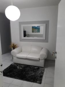 a white living room with a white couch and a picture at Isla Verde Apt Two-Bedroom in San Juan