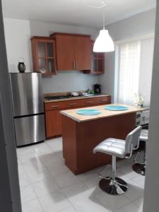 a kitchen with a island with a chair and a refrigerator at Isla Verde Apt Two-Bedroom in San Juan