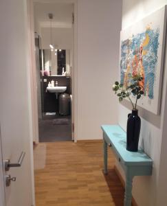 Un baño con una mesa azul con un jarrón. en Ferienwohnung am Zwinger en Dresden