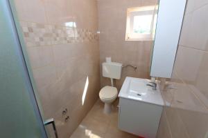 a bathroom with a white toilet and a sink at Marevista Apartments Dubravka in Stara Novalja