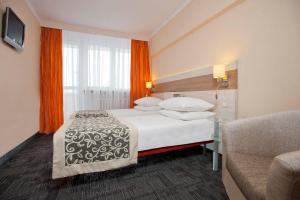 pokój hotelowy z łóżkiem i kanapą w obiekcie Comfort by Trio w mieście Białystok