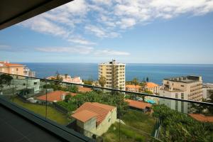 uma vista para o oceano a partir da varanda de um edifício em Spacious luxury holiday apartment with a great view, Funchal, free wifi and parking no Funchal
