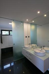 uma casa de banho com 3 lavatórios e um espelho grande em Spacious luxury holiday apartment with a great view, Funchal, free wifi and parking no Funchal