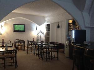 a dining room with tables and chairs and a tv at Hotel Nazareth in Lisbon