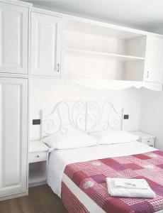 Un dormitorio blanco con una cama y armarios blancos. en Albergo Bel Soggiorno, en Fiumalbo
