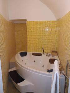 a bath tub in a bathroom with yellow tiles at Munaciello Rooms in Naples
