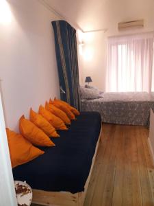a bedroom with two beds with orange pillows at Munaciello Rooms in Naples