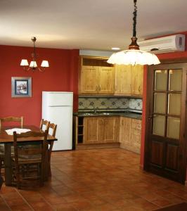 a kitchen with a table and a white refrigerator at La Casa del Seise in Baeza