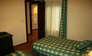 1 dormitorio con 1 cama y puerta con ventana en La Casa del Seise en Baeza