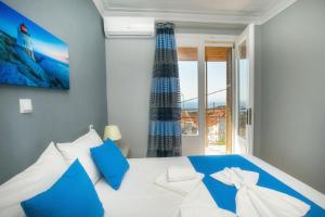 Schlafzimmer mit einem blauen und weißen Bett und einem Fenster in der Unterkunft Sotiria's House in Kallirákhi