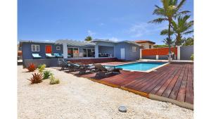 una casa con terrazza in legno e piscina di Aruba Haven a Palm Beach