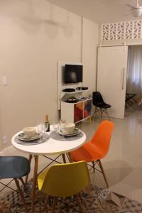 a room with a table with chairs and a tv at Copacabana, conforto e localização in Rio de Janeiro