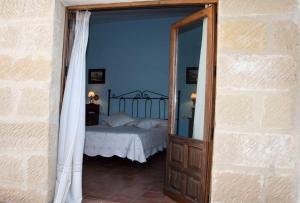 ein Schlafzimmer mit einem Bett und einem Spiegel in einem Zimmer in der Unterkunft La Casa del Seise in Baeza