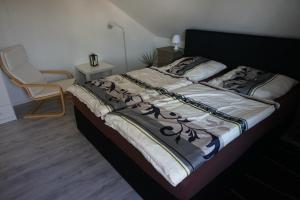 a large bed in a bedroom with a chair at Ferienwohnung am See in Bad Lippspringe