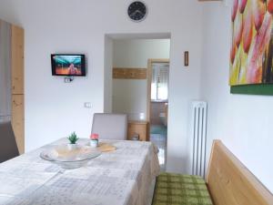 una sala da pranzo con tavolo e TV a parete di Ca Prandel CIPAT 22104-AT-65703 a Levico Terme
