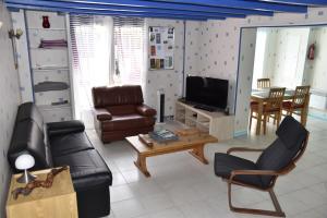 sala de estar con sofá y TV en Maison dans le vignoble de Bordeaux-Blaye-Bourg-CNPE en Saint-Trojan