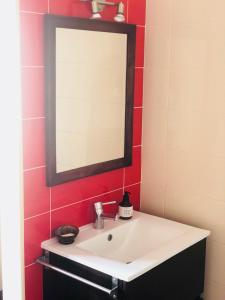 een badkamer met een witte wastafel en een spiegel bij Casa Milheiras in Almeirim