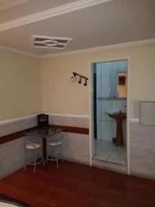 a bathroom with two chairs and a sink and a mirror at Motel Mont Blanc Gru in Guarulhos