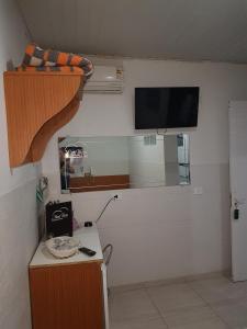 a room with a kitchen with a tv on the wall at Motel Mont Blanc Gru in Guarulhos +34 photos