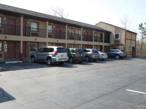 una fila de autos estacionados frente a un edificio en Red Carpet Inn Absecon, en Galloway