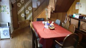 una mesa en una habitación con un mantel rojo en Guesthouse Taihei, en Aso