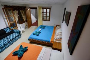 1 dormitorio pequeño con 1 cama y 1 sofá en The Galapagos Pearl B&B, en Puerto Ayora