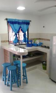 a kitchen with a table and stools in a kitchen at Divijuka in Taganga