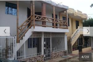 a house with a porch with a wooden deck at Divijuka in Taganga