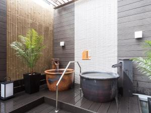 a bathroom with a large bath tub and plants at APA Hotel & Resort Nishishinjuku-Gochome-Eki Tower in Tokyo