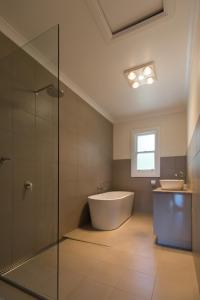 a bathroom with a bath tub and a sink at Leichhardt Cottages in Relbia +17 photos
