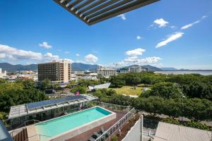 een uitzicht vanaf het balkon van een gebouw met een zwembad bij Cairns Private Apartments in Cairns