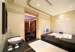 La salle de bains est pourvue d'un lavabo et d'une baignoire. dans l'établissement Amain Boutique Motel - Tucheng 217, à Tucheng