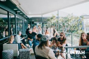 a group of people sitting at a table in a restaurant at Gunyah Hotel in Belmont