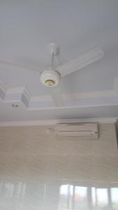 techo blanco con ventilador de techo y ventana en Rumah Ary Homestay & Spa, en Ubud