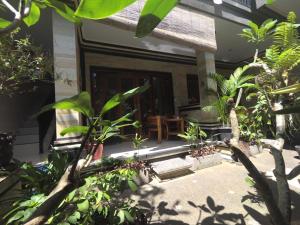 un porche de una casa con árboles y plantas en Rumah Ary Homestay & Spa, en Ubud