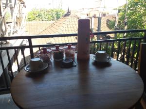 una mesa de madera con tazas y platillos en el balcón en Rumah Ary Homestay & Spa, en Ubud