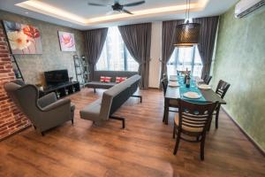 a living room with a table and chairs and a couch at Perfect Getaway @Vivacity in Kuching