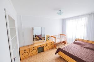 ein Schlafzimmer mit einem Bett und einem Spiegel auf einer Kommode in der Unterkunft Apartment on Polevaya 44/12 in Bohuslav