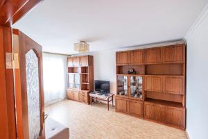 ein Wohnzimmer mit Holzschränken und einem TV in der Unterkunft Apartment on Polevaya 44/12 in Bohuslav